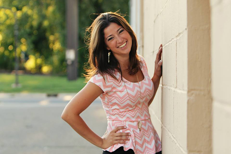 Communication senior Julianna Blain posing outdoors against a wall.