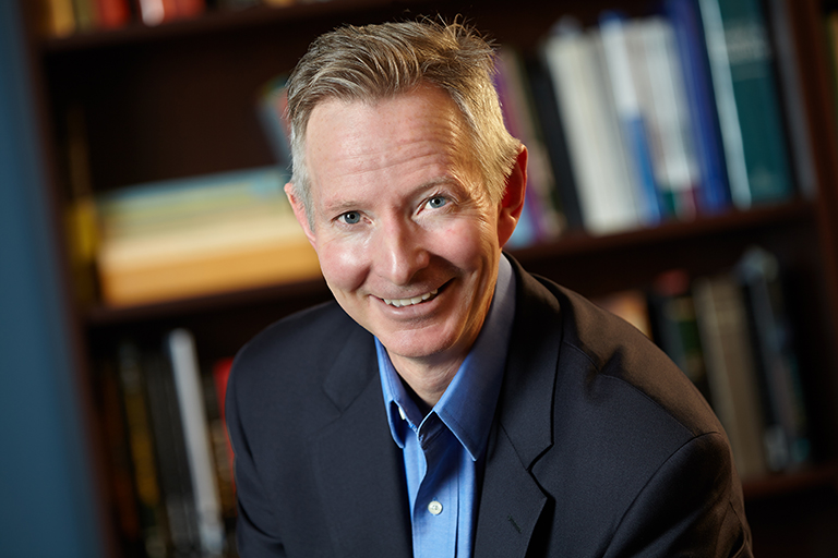 Department Chair James W. Dearing in front of bookcase