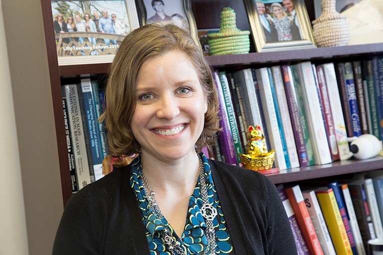 Professor Amanda Holmstrom standing in front of bookcase